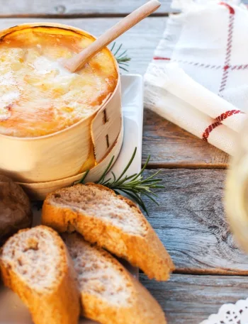 Mont d’Or au four fondant servi chaud avec pommes de terre et tranches de pain