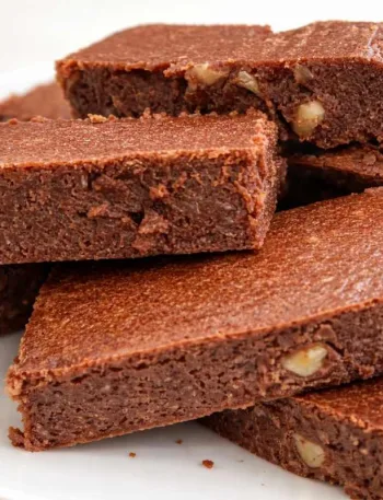 Brownies coupés en carrés empilés sur une assiette blanche