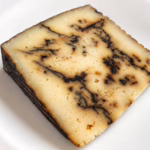 Tomme de brebis à l'ail noir sur une assiette blanche