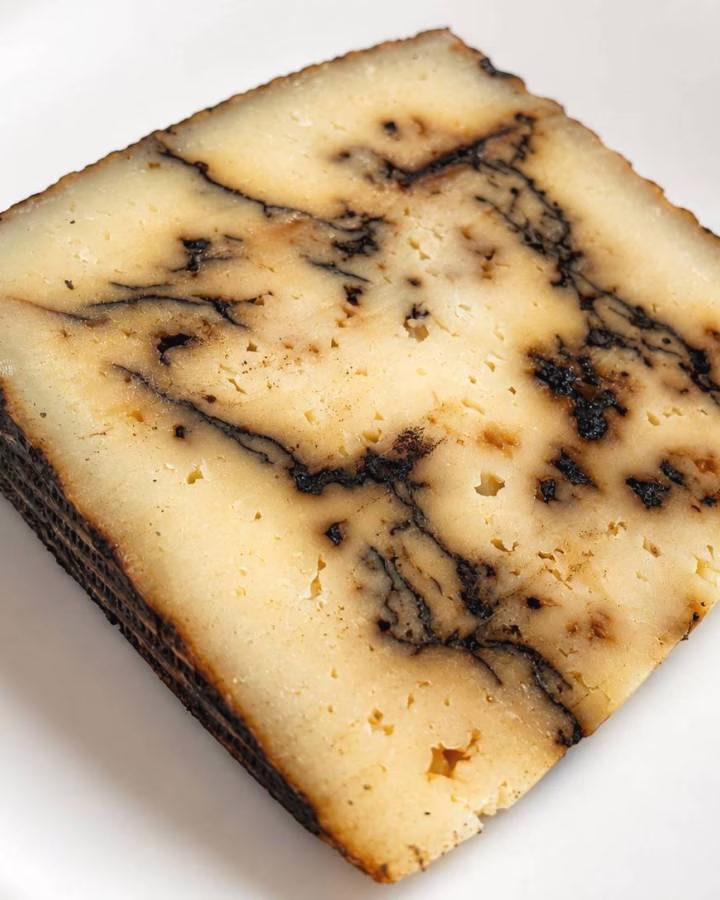 Tomme de brebis à l'ail noir sur une assiette blanche